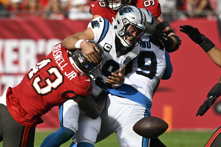 Tampa Bay Buccaneers linebacker Chris Braswell forces a fumble by Carolina Panthers quarterback Bryce Young during the second half of an NFL football game Sunday, Dec. 29, 2024, in Tampa, Fla. (AP Photo/Jason Behnken)