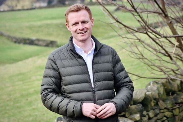 A man standing in a field with waterproof jacket on