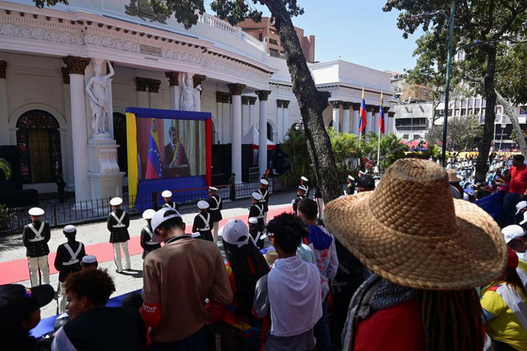 FILE PHOTO: People watch a screen as Venezuela's President Nicolas Maduro is sworn in for a third six-year term, in Caracas, Venezuela January 10, 2025. REUTERS/Gaby Oraa/File Photo