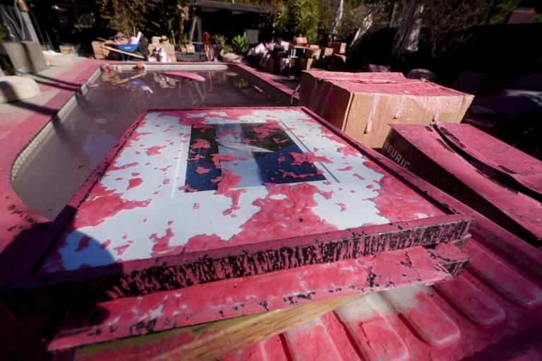 La piscina de una vivienda es cubierta por el polvo rosa, evidenciando el paso de los aviones cisterna que luchan contra los incendios en California. / AP.