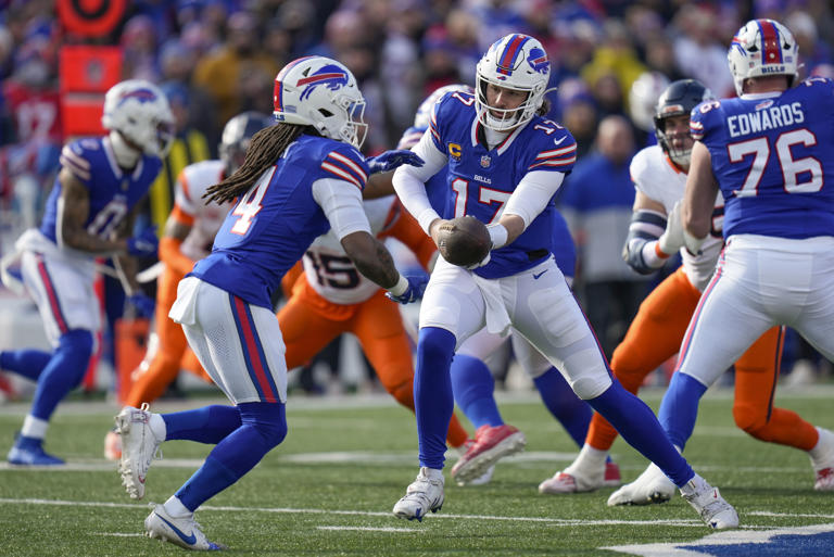 El quarterback de los Bills de Buffalo Josh Allen le entrega el balón al corredor James Cook en el encuentro de comodín ante los Broncos de Denver el domingo 12 de enero del 2025. (AP Foto/Seth Wenig)