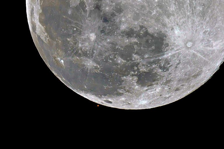 Mars hides behind the Full Wolf Moon in photos from around the world