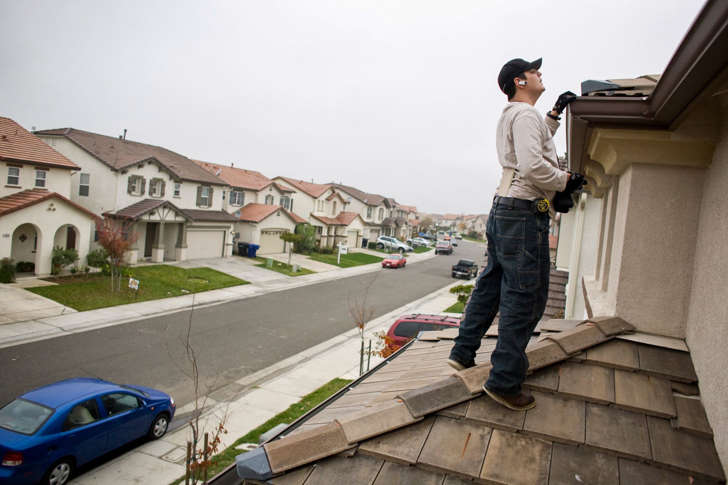 NorthWoods inspector Manny Nevarez inspects the roof of a foreclosed home for needed repairs December 2, 2008 in Sacramento, California. Many foreclosed homes need substantial repairs before going on the market.