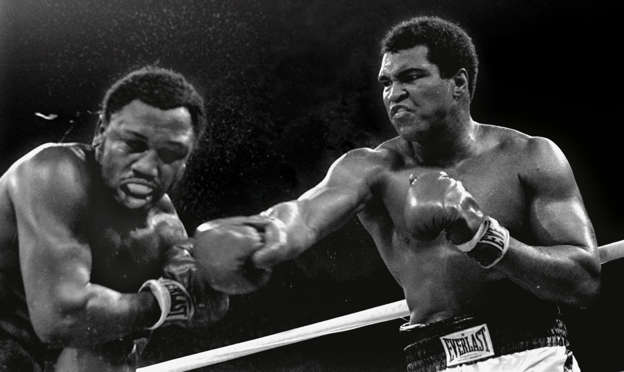Spray flies from the head of Frazier as Ali connects with a right in the ninth round of their title fight in Manila, Philippines, Oct. 1, 1975. Ali won the fight on a decision to retain the title.