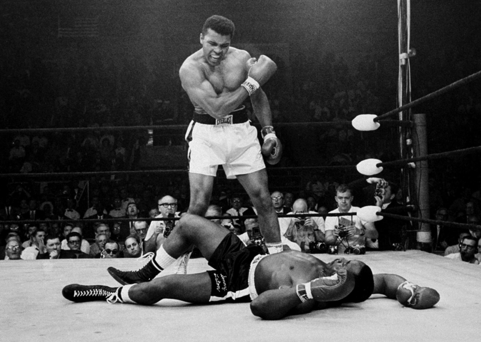 Ali stands over fallen challenger Sonny Liston, shouting and gesturing shortly after dropping Liston with a short hard right to the jaw on May 25, 1965, in Lewiston, Maine. The bout lasted only one minute.