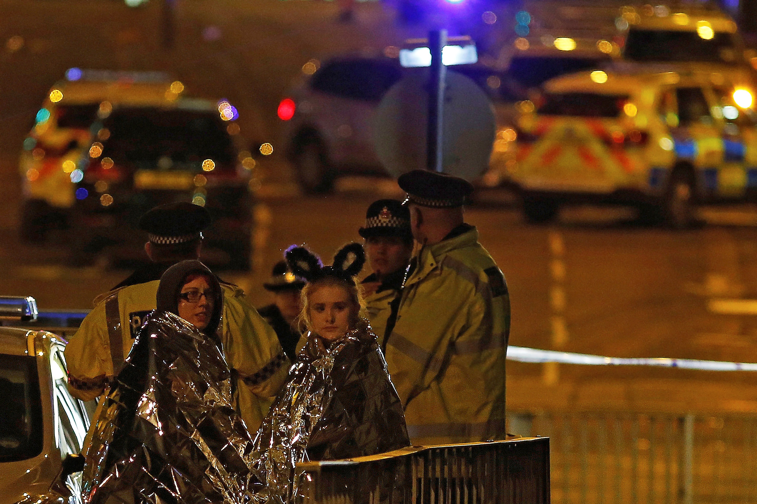 Slide 15 of 27: Two women wrapped in thermal blankets look on near the Manchester Arena, where U.S. singer Ariana Grande had been performing, in Manchester, northern England, Britain May 23, 2017.
