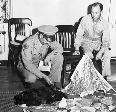 Slide 3 of 13: Brig. General Roger M. Ramey, Commanding General of 8th Airforce, and Col. Thomas J. Dubose, 8th Airforce Chief of Staff, identify metallic fragments found by a farmer near Roswell, New Mexico, as pieces of a weather balloon. This is the basis of the Roswell Incident, the supposed crash of an alien spacecraft.