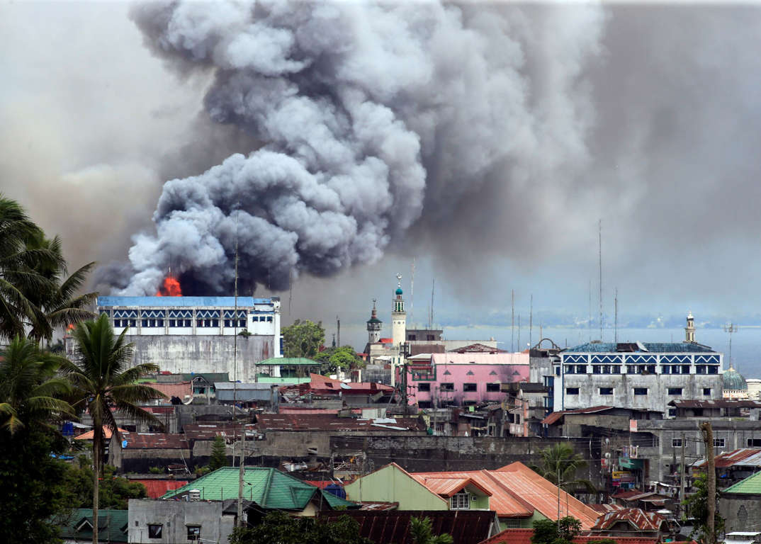 Slide 7 of 33: Black smoke comes from a burning building in a commercial area of Osmena street in Marawi city, Philippines June 14, 2017. REUTERS/Romeo Ranoco TPX IMAGES OF THE