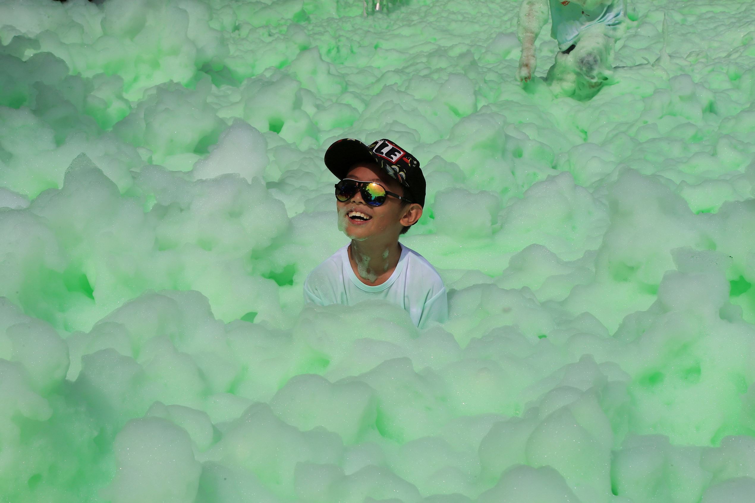 Slide 18 of 33: A child smiles as he participates in a color run event in Beijing, China June 10, 2017. REUTERS/Stringer ATTENTION EDITORS - THIS IMAGE WAS PROVIDED BY A THIRD PARTY. CHINA OUT. NO COMMERCIAL OR EDITORIAL SALES IN CHINA. TPX IMAGES OF THE