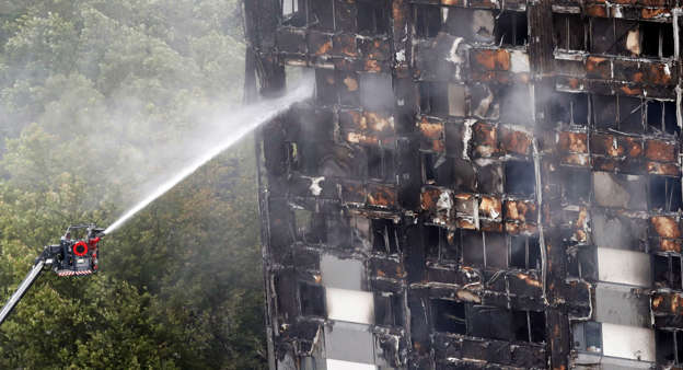Firefighters continue to damp-down the deadly fire at Grenfell Tower in London, Thursday, June 15, 2017.  A massive fire raced through the 24-storey high-rise apartment building in west London early Wednesday, and London fire commissioner says it will take weeks for the building to be searched and 'cleared'.