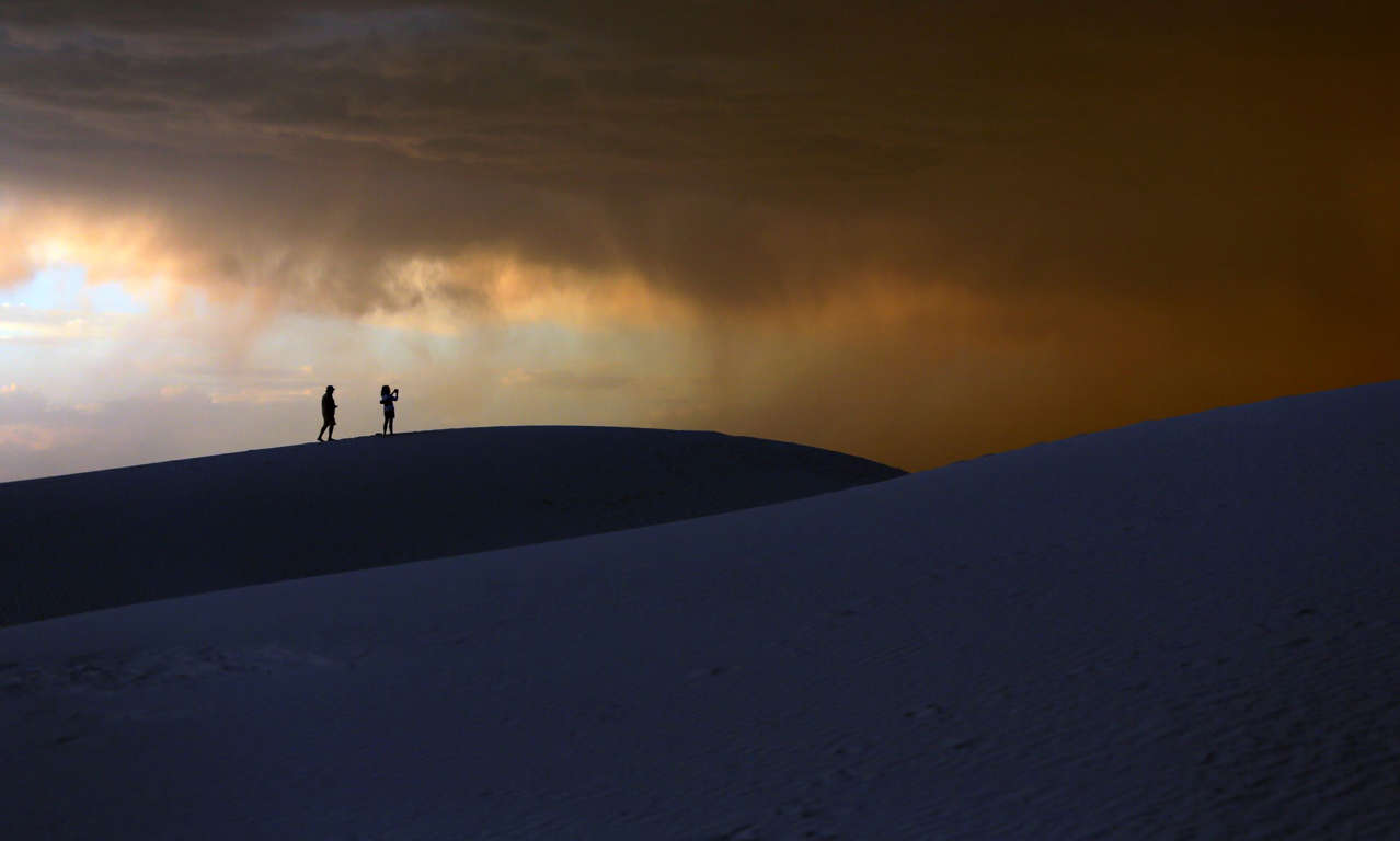 Slide 3 of 40: A storm moves in over a couple visiting White Sands National Monument, Wednesday, June 21, 2017, near Alamogordo, N.M. Temperatures in the area hit 105 degrees Wednesday. (AP Photo/Eric Gay)