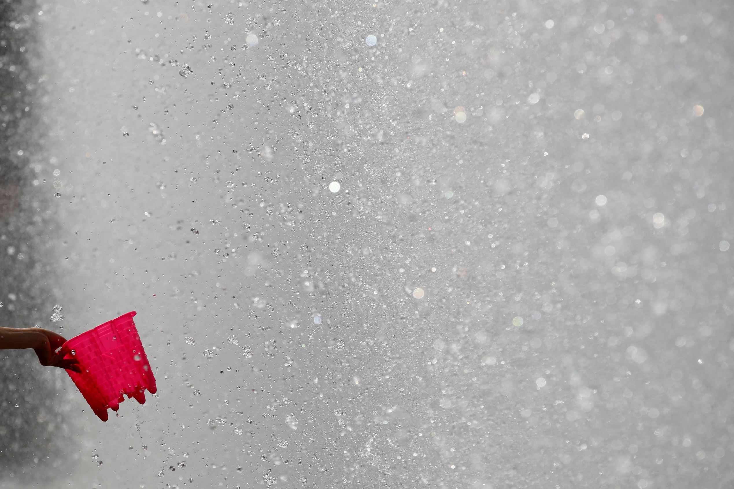 Slide 2 of 40: A girl cools down near a fountain in Battersea Park during a hot day in London, Britain June 21, 2017. REUTERS/Stefan