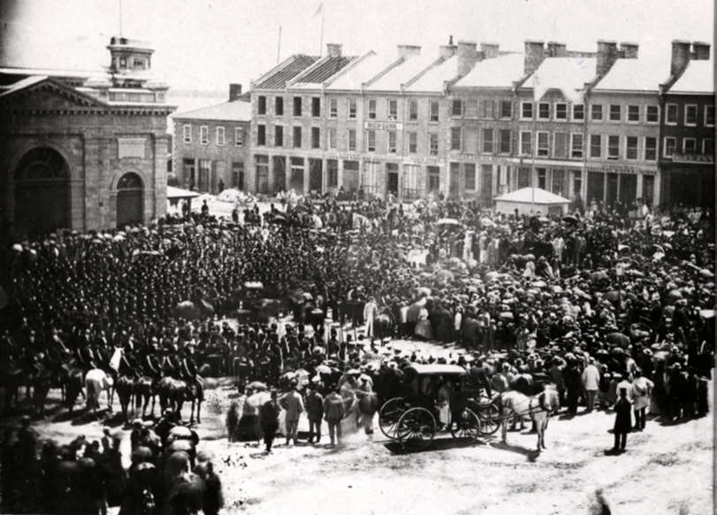 Slide 2 of 11: Image Caption: People crowded into Kingston, Ontarioâs Market Square on July 1, 1867, as the confederation of Canada was proclaimed.