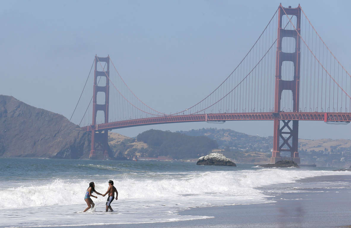 Slide 10 of 40: Children play in the surf at Baker Beach with the Golden Gate Bridge shown at rear in San Francisco, Wednesday, June 21, 2017. The first day of summer is going to be a hot one in the San Francisco Bay Area. The National Weather Service has issued an excessive heat warning for the area through Thursday night.