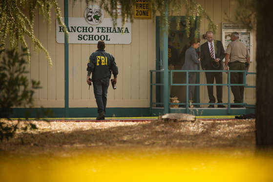 FBI agents are seen behind yellow crime scene tape outside Rancho Tehama Elementary School after a shooting in the morning on November 14, 2017, in Rancho Tehama, California Four people were killed and nearly a dozen were wounded, including several children, when a gunman went on a rampage at multiple locations, including a school in rural northern California.
