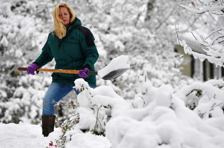 In this Saturday, Dec. 9, 2017 file photo, Laura Washington shovels her walk after a heavy snow, in Kennesaw, Ga. Thousands remained without electricity across the Deep South on Monday, Dec. 11, days after the storm snapped power lines across the region. Metro Atlanta got several inches of snow Friday and Saturday, while some areas farther north saw up to a foot of snowfall.