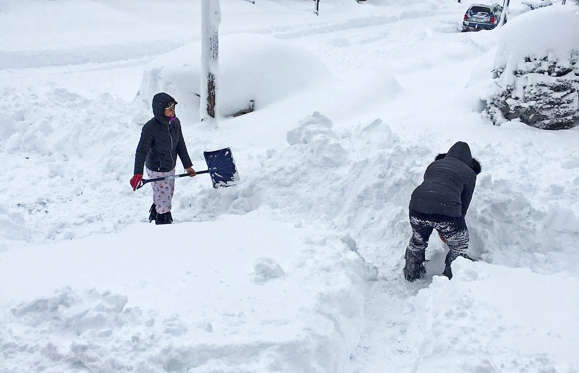 Slide 1 of 42: People dig out the path by their house after the record snowfall in Erie, U.S., December 26, 2017 in this picture obtained from social media.