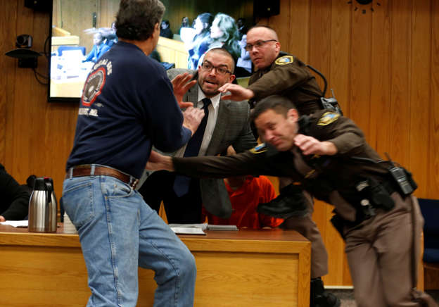 Randall Margraves (L) lunges at Larry Nassar,(wearing orange) a former team USA Gymnastics doctor who pleaded guilty in November 2017 to sexual assault charges, during victim statements of his sentencing in the Eaton County Circuit Court in Charlotte, Michigan, U.S., February 2, 2018