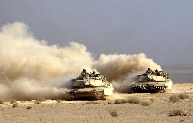 Slide 5 of 50: IRAQ - MARCH 23: A U.S. Army 3rd Infantry Division M1/A1 Abrahms tank rolls deeper into Iraqi territory March 23, 2003 south of the city of An Najaf, Iraq. U.S. and British forces continue to assault Iraq from land, sea and air as part of the ongoing Operation Iraqi Freedom. (Photo by Scott Nelson/Getty Images)