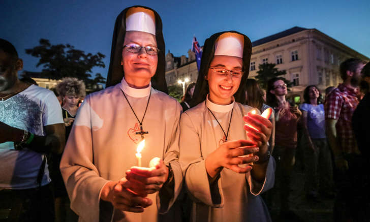 Two pilgrims hold candles at World Youth Day in Krakow, Poland: Freiras poloneses levam velas em Crac&oacute;via