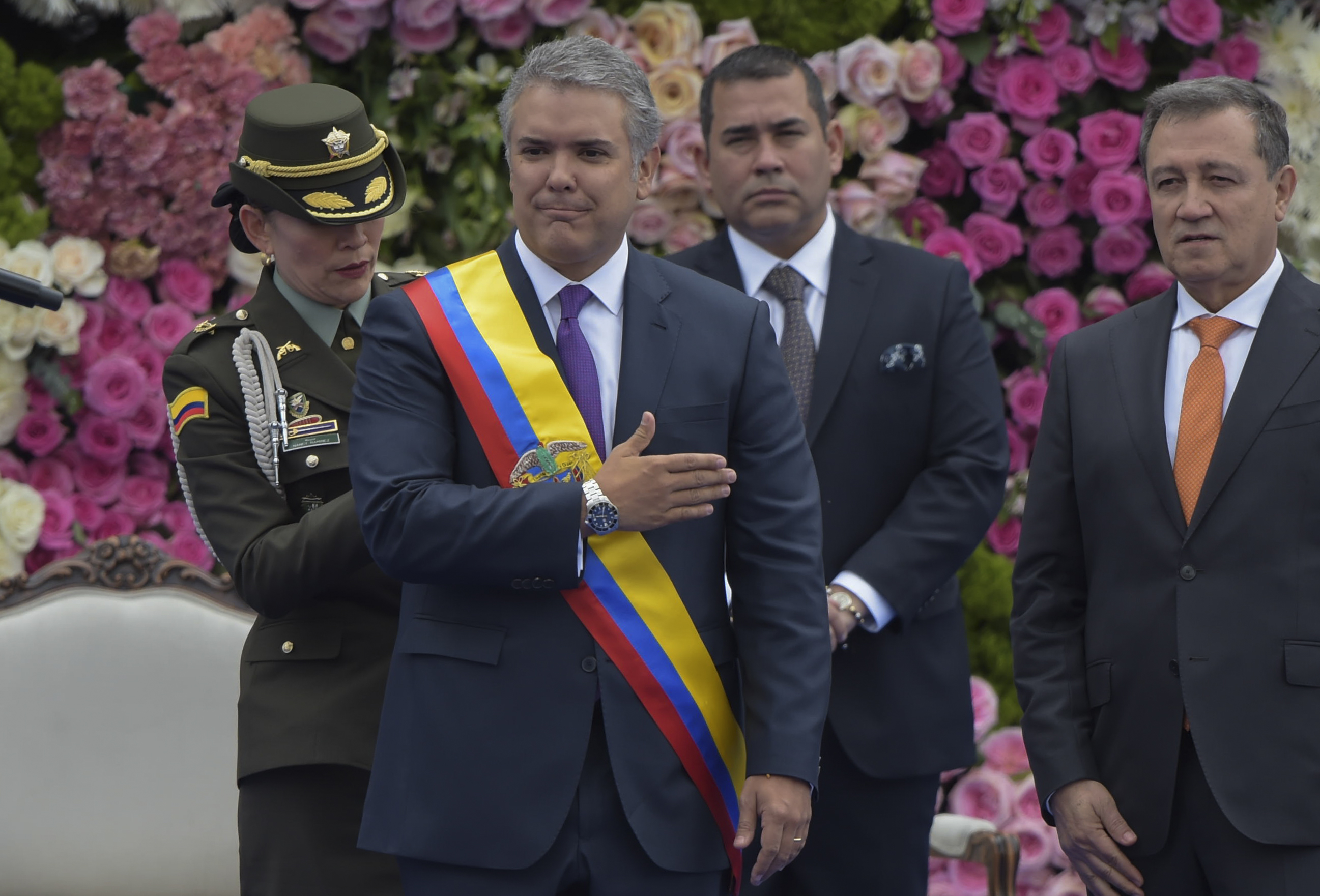 Slide 3 de 33: Colombia's new President Ivan Duque (C) gestures as the presidential sash is adjusted and and the Senate President Ernesto Macias (L) and the president of the Lower House Carlos Chacon (R) look on during the inauguration ceremony at Bolivar Square in Bogota, on August 7, 2018. - Duque has his work cut out for him as he takes office Tuesday amid heightened tensions with neighbouring Venezuela and the lingering difficulties of peace-building with the nation's rebel groups. (Photo by Raul ARBOLEDA / AFP)        (Photo credit should read RAUL ARBOLEDA/AFP/Getty Images)