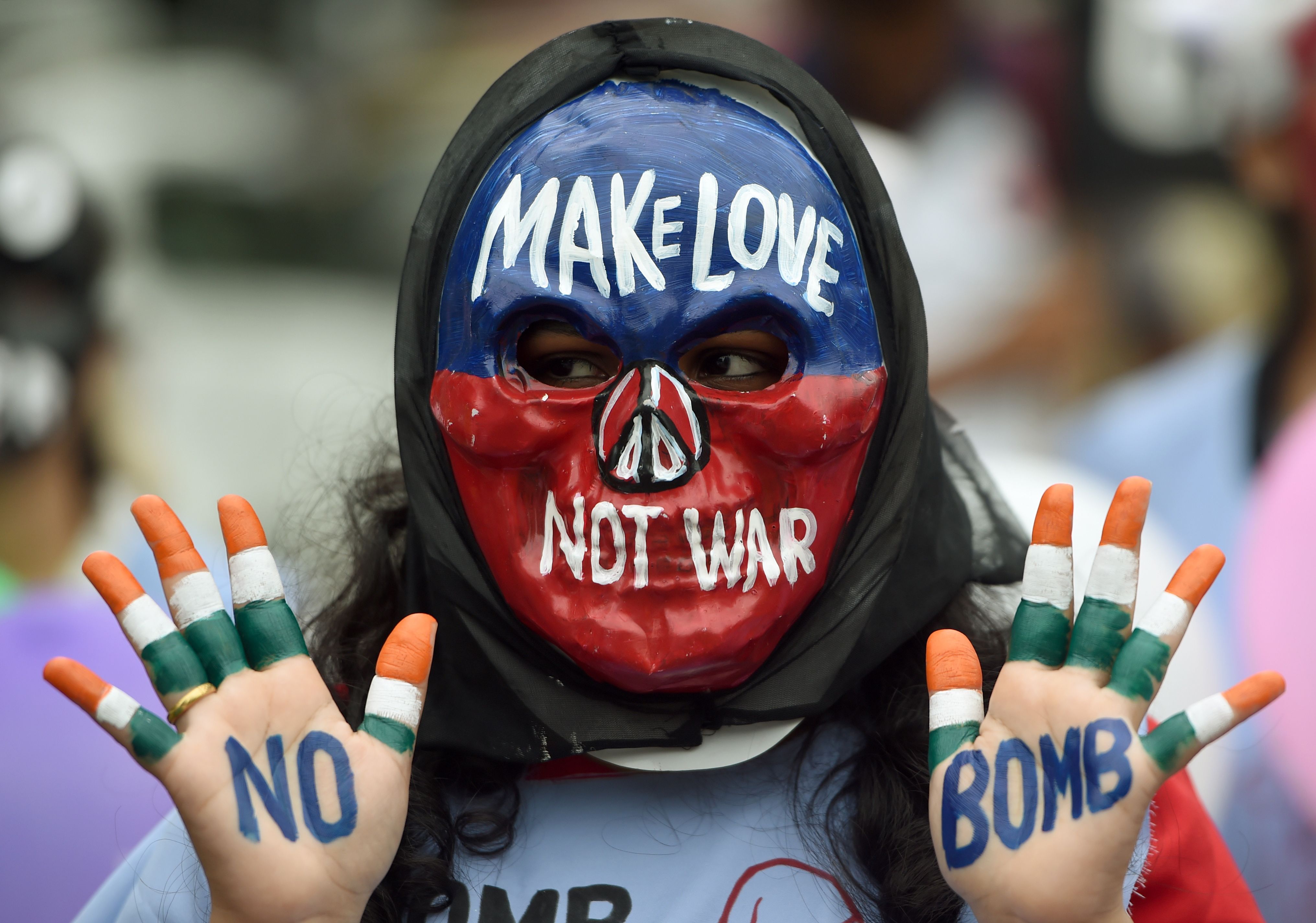 Slide 13 de 33: TOPSHOT - An Indian student wearing a mask poses with her hands painted with a slogans for peace during a rally to mark Hiroshima Day, in Mumbai on August 6, 2018. - Hiroshima Day commemorates August 6 of 1945, the day an atomic bomb was dropped on the Japanese city of Hiroshima. (Photo by PUNIT PARANJPE / AFP)        (Photo credit should read PUNIT PARANJPE/AFP/Getty Images)