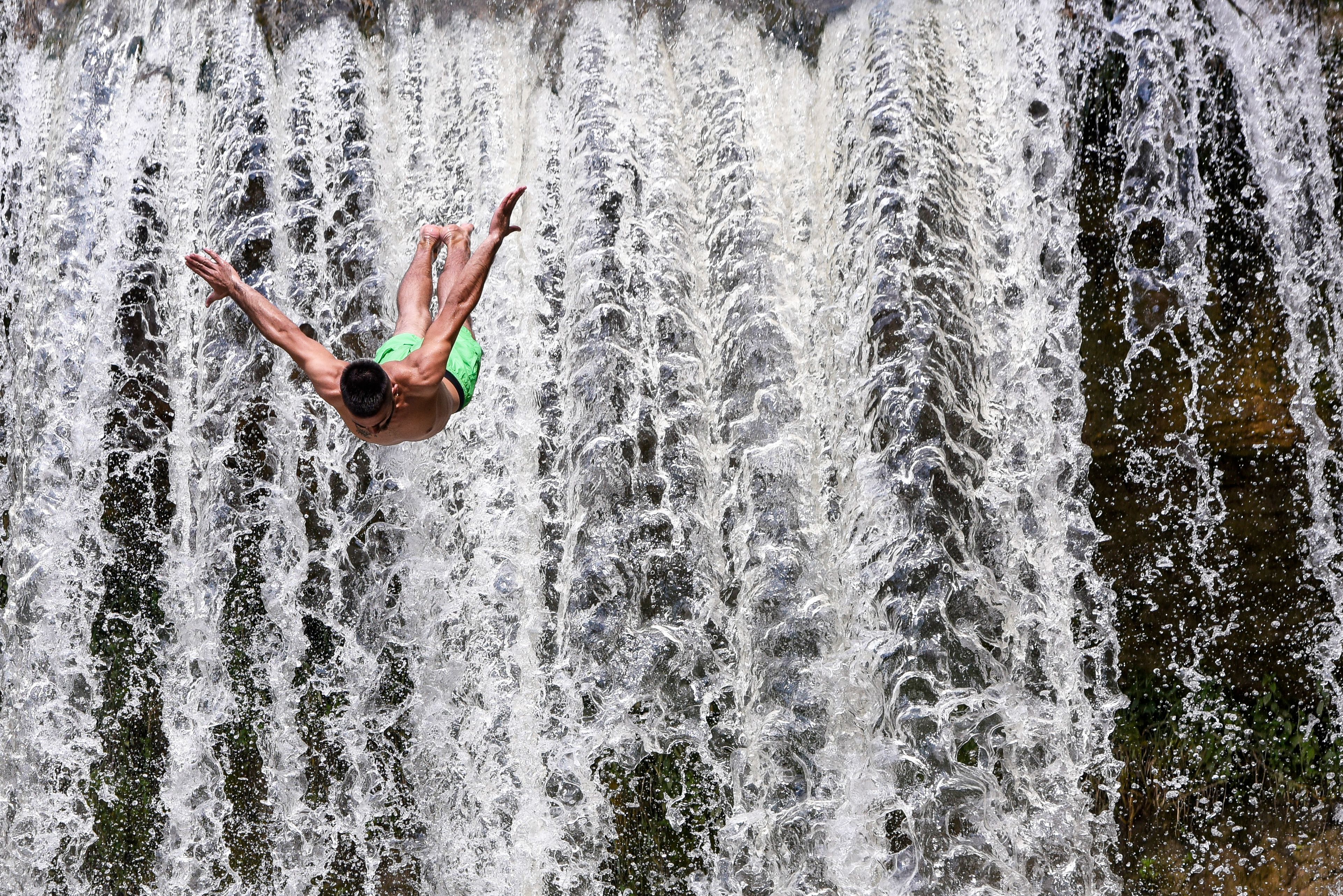 Slide 6 de 33: A diver jumps during a high diving competition at the Mirusha waterfalls, near the village of Lapceve, on August 5, 2018. (Photo by Armend NIMANI / AFP)        (Photo credit should read ARMEND NIMANI/AFP/Getty Images)