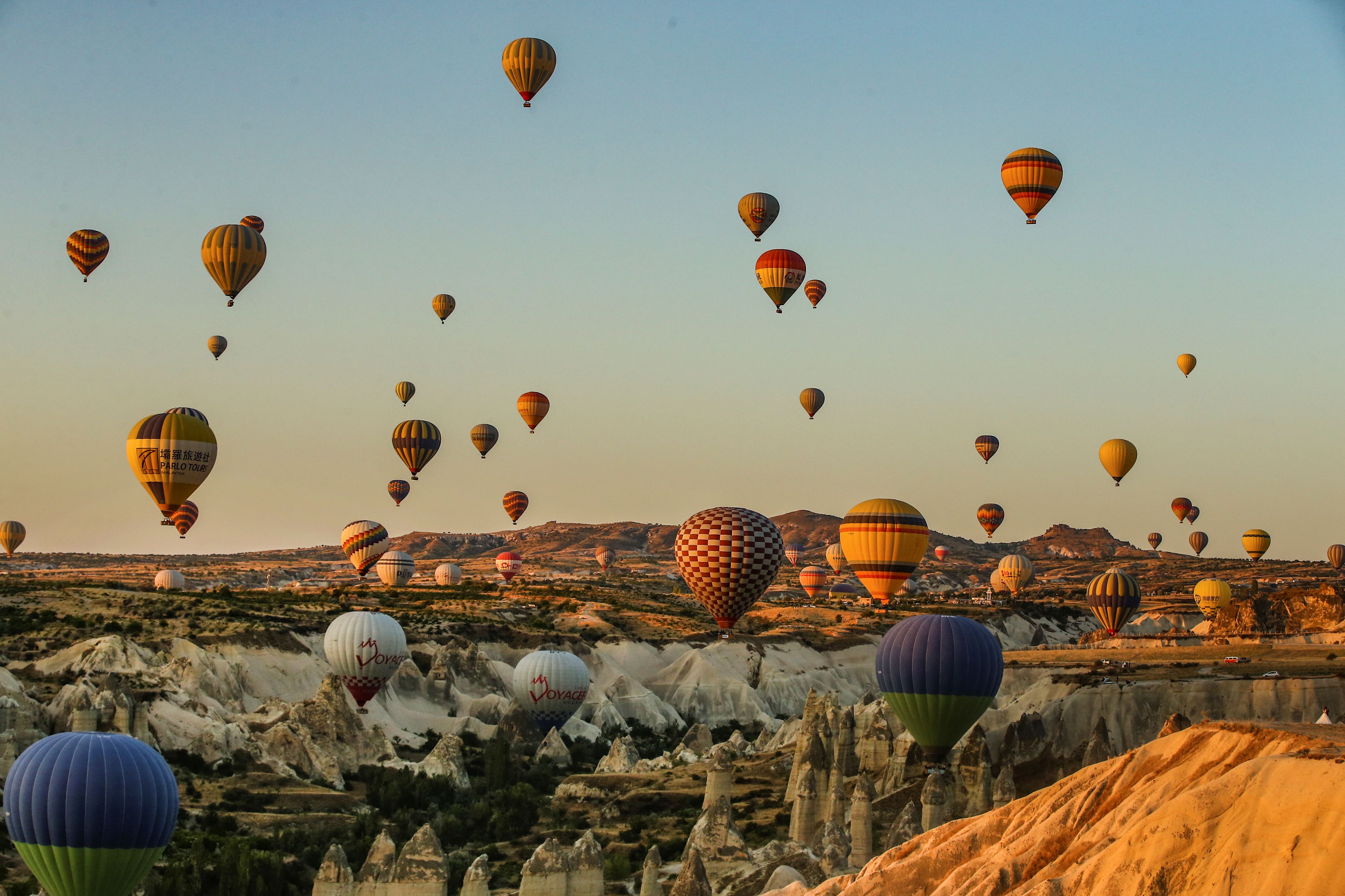 Slide 12 de 33: Hot air balloons, carrying tourists, rise into the sky at sunrise in Cappadocia, central Turkey, early Tuesday, Aug. 7, 2018.  Cappadocia has become a favourite site for tourists in hot-air balloons who can slowly drift above the cone-shaped rock formations and then float up over rippled ravines for breathtaking views over the region.(AP Photo/Emrah Gurel)