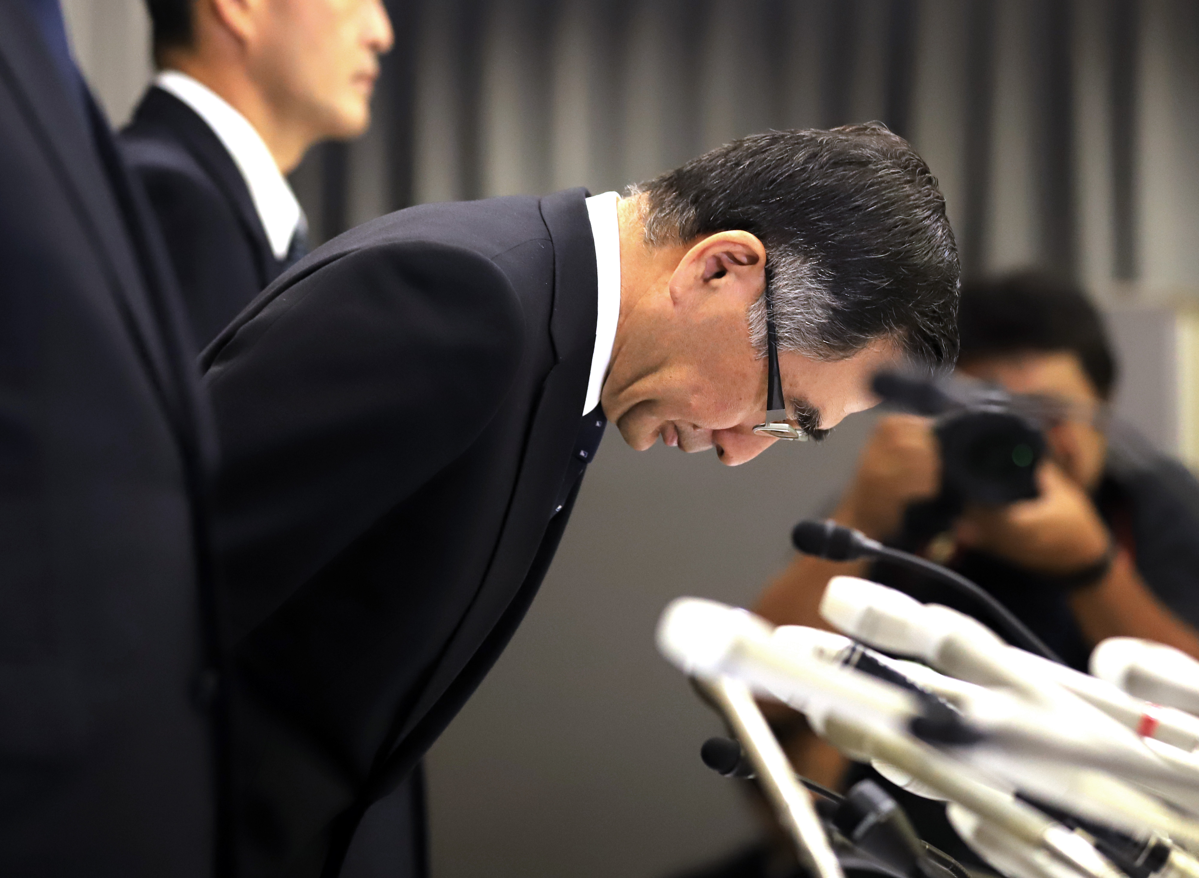 Slide 5 de 33: Japan's automaker Suzuki Motor president Toshihiro Suzuki bows his head to apologize for the company's data cover-up on fuel economy and emissions at the in-house investigation
