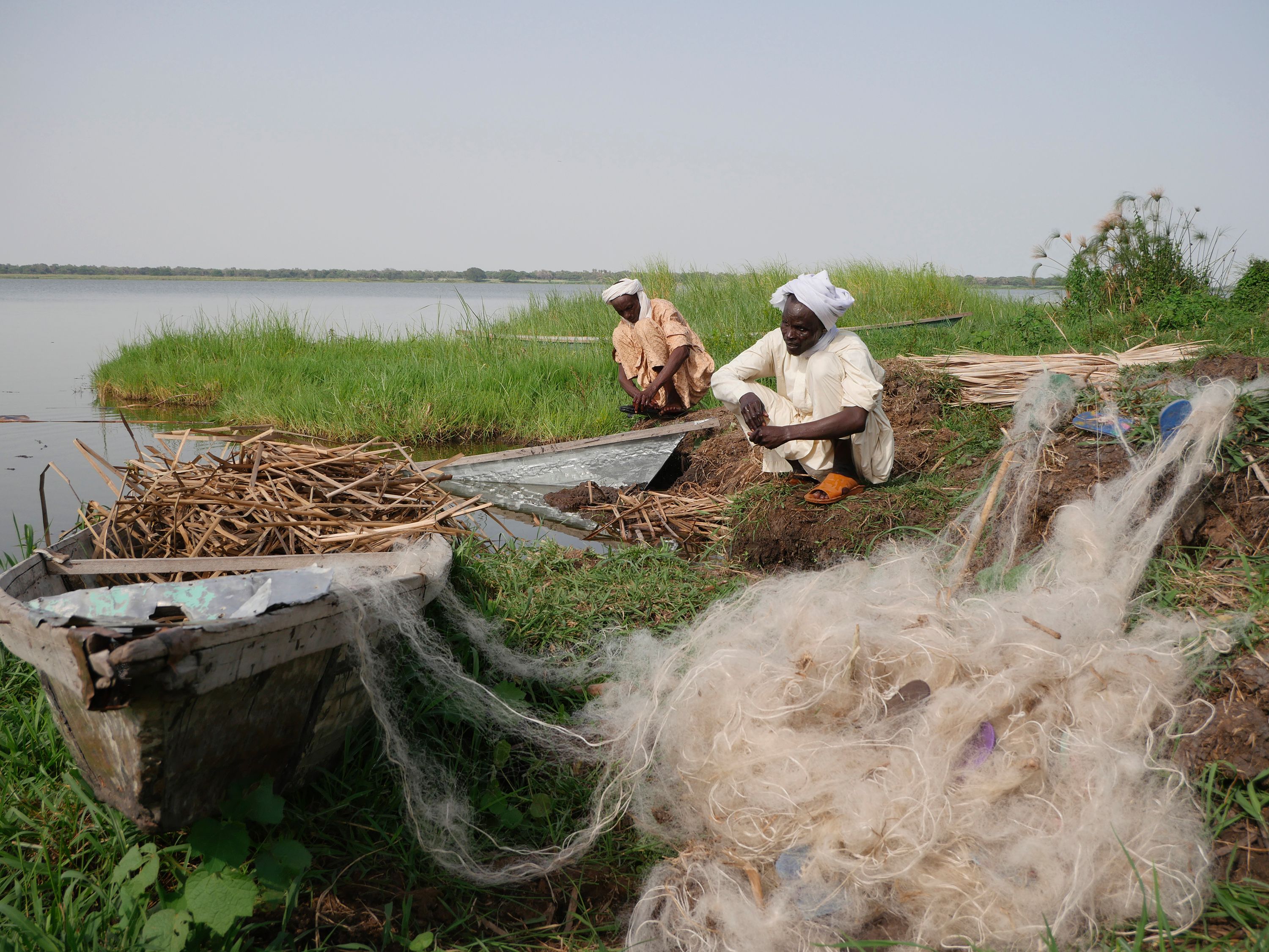 Chadian fishermen mend their nets on Midikouta Island on Lake Chad on July 22, 2017.