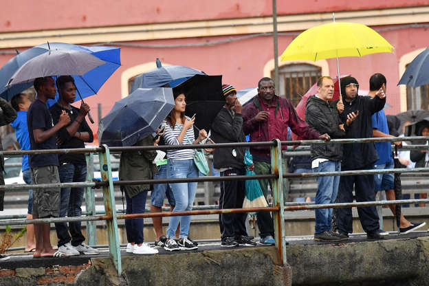 Slide 11 de 20: People look at the collapsed bridge in Genoa, Italy, 14 August 2018.