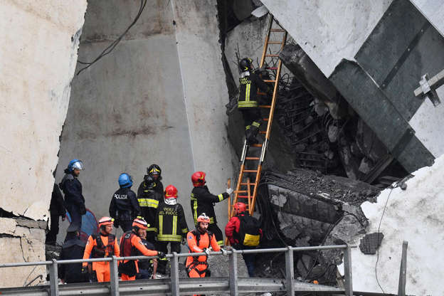 Slide 7 de 20: Rescuers at the site of the collapsed bridge in Genoa, Italy, 14 August 2018.