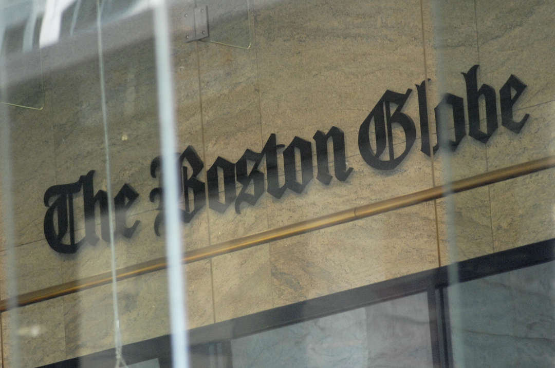 The Boston Globe logo as seen through the windows across from the new location of the Boston Globe at 53 State Street, Boston, at one Exchange Place in the Exchange Building on August 15, 2018. (Photo by Joseph PREZIOSO / AFP)        (Photo credit should read JOSEPH PREZIOSO/AFP/Getty Images)