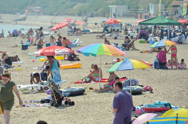 People enjoy the sunshine on the beach at Clacton-on-Sea in Essex