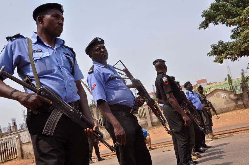 FILE- In this Saturday Feb. 7, 2015 file photo Nigeria police officers block a road in the city of Abuja, Nigeria.