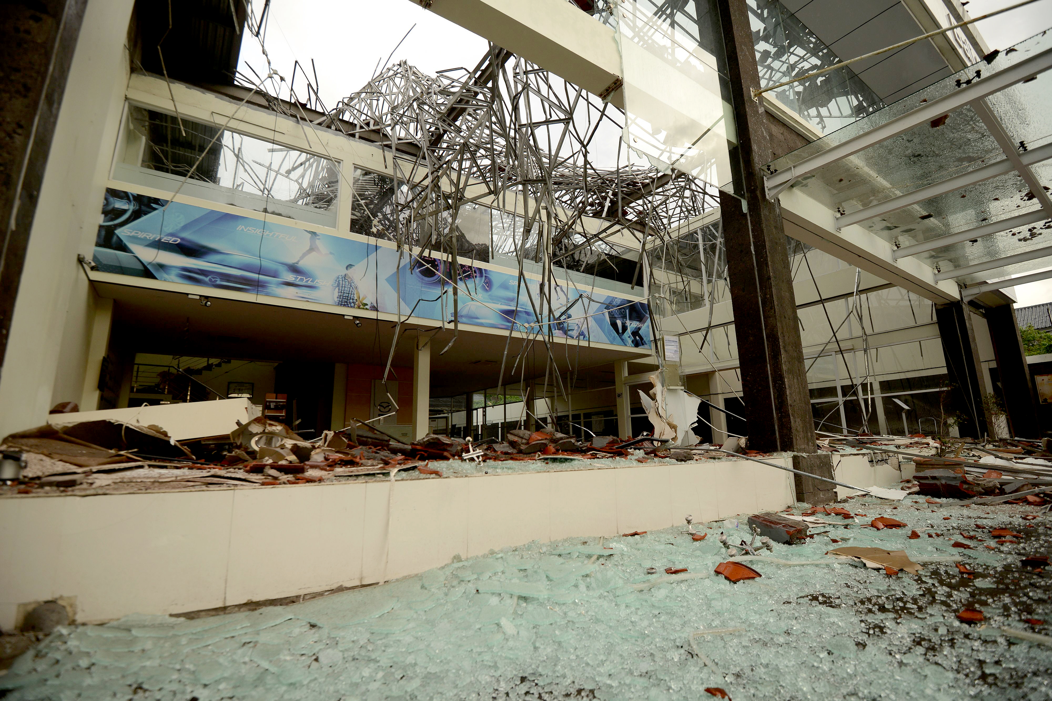 Slide 1 of 11: Debris is seen at a shop in Denpasar on Indonesia's resort island of Bali on August 6, 2018, after it was damaged in an earthquake that struck Lombok. - A powerful quake which struck the Indonesian holiday island of Lombok has killed 82 people and wounded hundreds, national disaster agency spokesman Sutopo Purwo Nugroho said early on August 6, with thousands of buildings left damaged. The 6.9 magnitude tremor, which triggered panic among tourists and locals on Sunday evening, was also felt on the neighbouring island of Bali, one of Southeast Asia's leading tourist destinations.