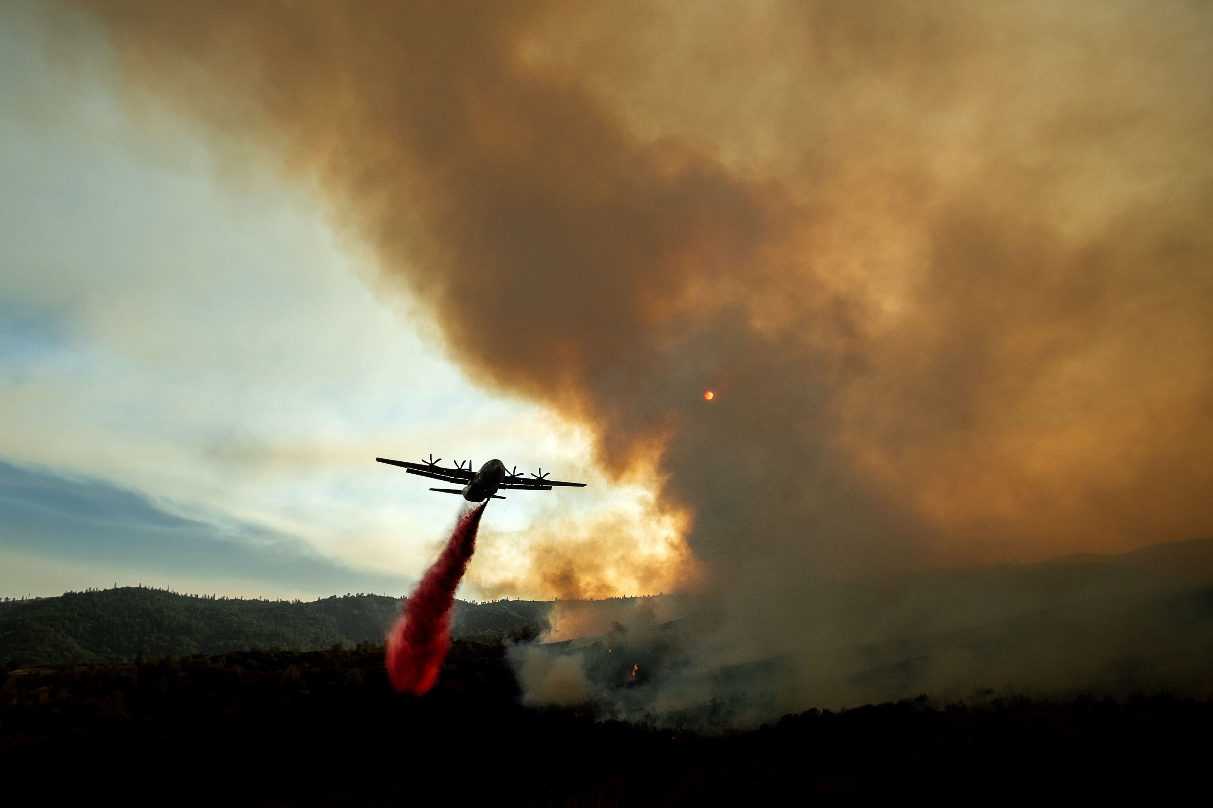 An air tanker drops retardant on the Ranch Fire, part of the Mendocino Complex Fire, burning along High Valley Rd near Clearlake Oaks, California, on August 5, 2018. - Several thousand people have been evacuated as various fires swept across the state, although some have been given permission in recent days to return to their homes. (Photo by NOAH BERGER / AFP)        (Photo credit should read NOAH BERGER/AFP/Getty Images)