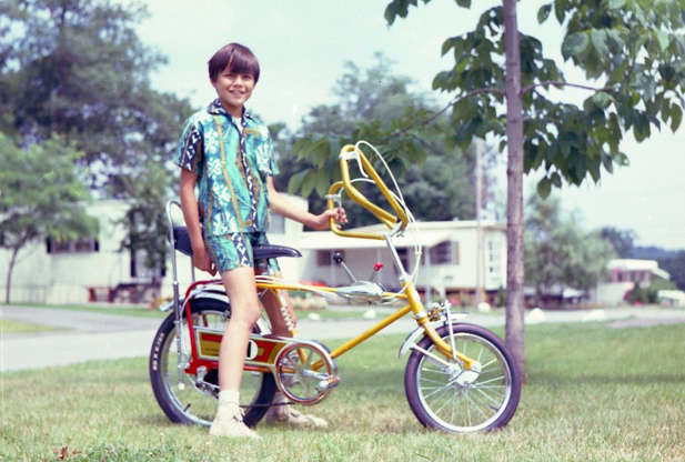 Diapositiva 66 de 101: The banana bikeâ??also known as a wheelie bike, high-riser, spyder bike, consisted of ape hanger handlebars, a banana seat with sissy bar, and small wheels. They were designed to resemble a chopper motorcycle, and if you were a kid, nothing was cooler than racing down the street in one of these babies.