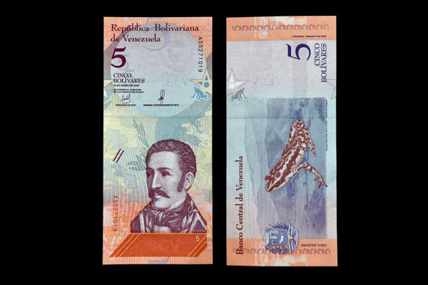 Slayt 5/65: A woman holds new Bolivar-notes in downtown Caracas on August 21, 2018. - Caracas is issuing new banknotes after lopping five zeroes off the crippled bolivar, casting a pall of uncertainty over businesses and consumers across the country. (Photo by Federico PARRA / AFP)        (Photo credit should read FEDERICO PARRA/AFP/Getty Images)