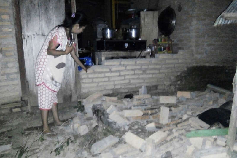 A resident is seen beside the collapsed brick wall of her house at Tobadak village in Central Mamuju, western Sulawesi province, on September 28, 2018, after a strong earthquake hit the area. - Indonesia was rocked by a powerful 7.5 magnitude earthquake on September 28, just hours after at least one person was killed by a collapsing building in the same part of the country. (Photo by NURPADILA / AFP)        (Photo credit should read NURPADILA/AFP/Getty Images)