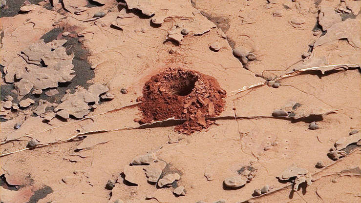 Slide 2 de 25: This close-up image is of a 2-inch-deep hole produced using a new drilling technique for NASA's Curiosity rover. The hole is about 0.6 inches (1.6 centimeters) in diameter. This image was taken by Curiosity's Mast Camera (Mastcam) on Sol 2057. It has been white balanced and contrast-enhanced.

Curiosity drilled this hole in a target called "Duluth" on May 20, 2018. It was the first rock sample captured by the drill since October 2016. A mechanical issue took the drill offline in December 2016.

Engineers at NASA's Jet Propulsion Laboratory had to innovate a new way for the rover to drill in order to restore this ability. The new technique, called Feed Extended Drilling (FED) keeps the drill's bit extended out past two stabilizer posts that were originally used to steady the drill against Martian rocks. It lets Curiosity drill using the force of its robotic arm, a little more like a human would while drilling into a wall at home.