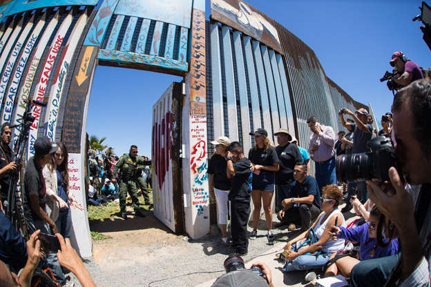 A Border Patrol agent closes the door after 6 families gathered at the border gather at the U.S.-Mexico Border during the opening of the door at the U.S. border wall in Tijuana, Mexico on April 30, 2017