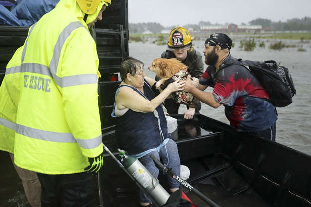 Slide 1 of 87: Rescue workers from Township No. 7 Fire Department and volunteers from the Civilian Crisis Response Team help rescue a woman and her dog from their flooded home during Hurricane Florence Sept. 14 in James City. Hurricane Florence made landfall in North Carolina as a Category 1 storm and flooding from the heavy rain is forcing hundreds of people to call for emergency rescues in the area around New Bern, North Carolina, which sits at the confluence of the Nueces and Trent rivers.