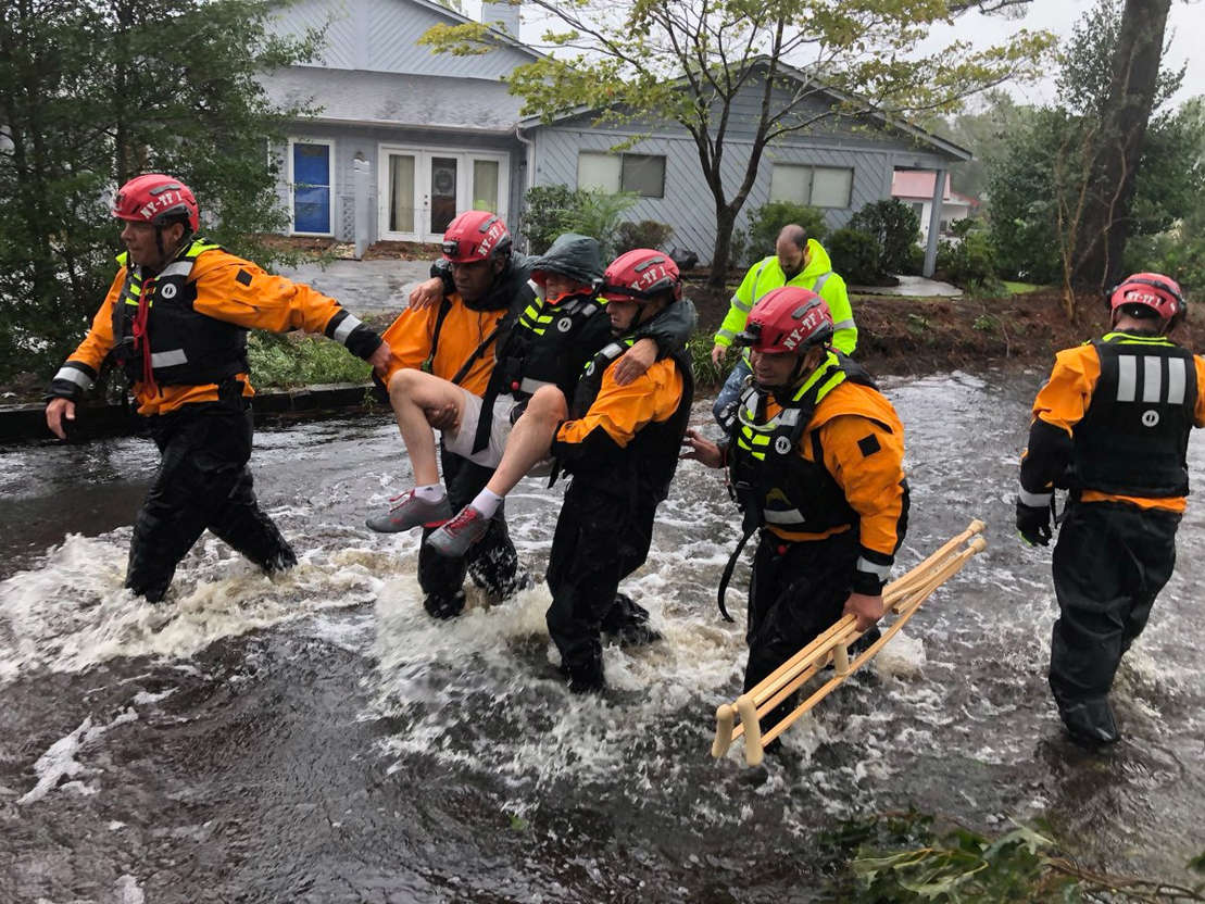 Slide 2 of 69: Search and Rescue workers from New York rescue a man from flooding caused by Hurricane Florence in River Bend, North Carolina, U.S. in this September 14, 2018 handout photo.   NYC Emergency Management/Handout via REUTERS  ATTENTION EDITORS - THIS IMAGE WAS PROVIDED BY A THIRD PARTY. - RC1CA0E50C50
