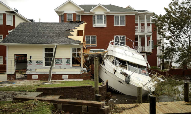 Slide 1 of 124: NEW BERN, NC - SEPTEMBER 15:  A boat lays smashed against a car garage, deposited there by the high winds and storm surge from Hurricane Florence along the Neuse River September 15, 2018 in New Bern, North Carolina. Hurricane Florence made landfall in North Carolina as a Category 1 storm Friday and at least five deaths have been attributed to the storm, which continues to produce heavy rain and strong winds extending out nearly 200 miles.  (Photo by Chip Somodevilla/Getty Images)