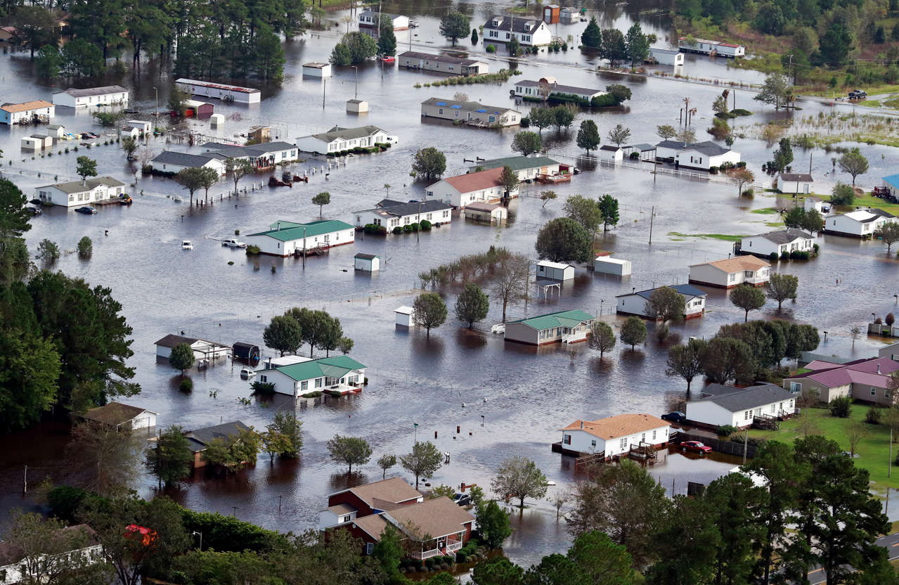 Slide 1 of 86: Houses sit in floodwater caused by Hurricane Florence, in this aerial picture, on the outskirts of Lumberton, North Carolina, U.S. September 17, 2018.