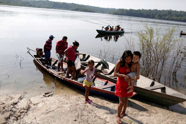 Slide 28 de 41: Pssoas chegam de canoa para votar em Sao Sebastiao do Cuieiras, no Amazonas