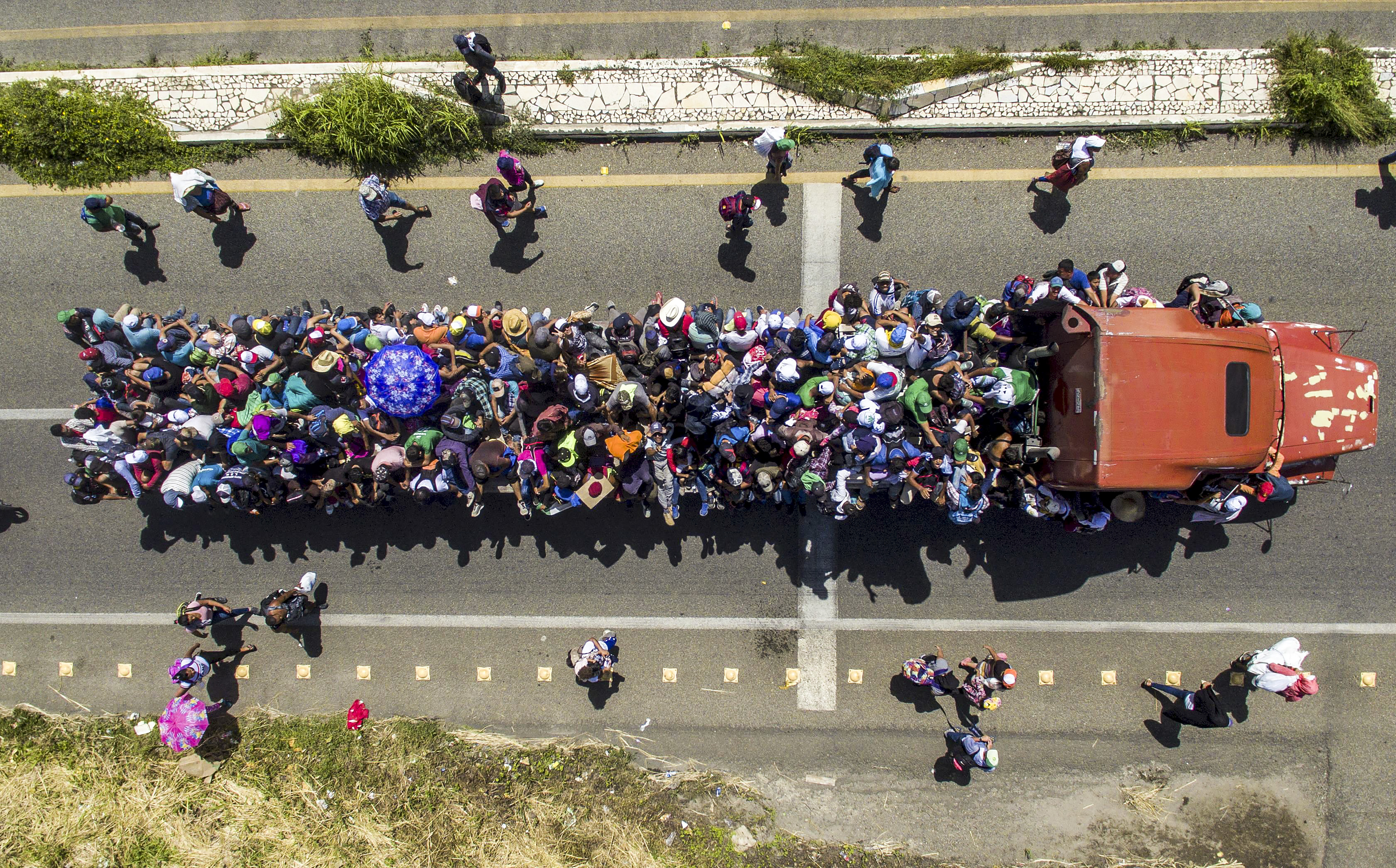 Slide 25 of 39: Aerial view of Honduran migrants onboard a truck as they take part in a caravan heading to the US, in the outskirts of Tapachula, on their way to Huixtla, Chiapas state, Mexico, on Oct. 22. - President Donald Trump on Monday called the migrant caravan heading toward the US-Mexico border a national emergency, saying he has alerted the US border patrol and military.