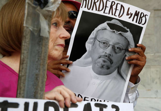 FILE - In this Oct. 10, 2018, file photo, people hold signs during a protest at the Embassy of Saudi Arabia about the disappearance of Saudi journalist Jamal Khashoggi, in Washington.