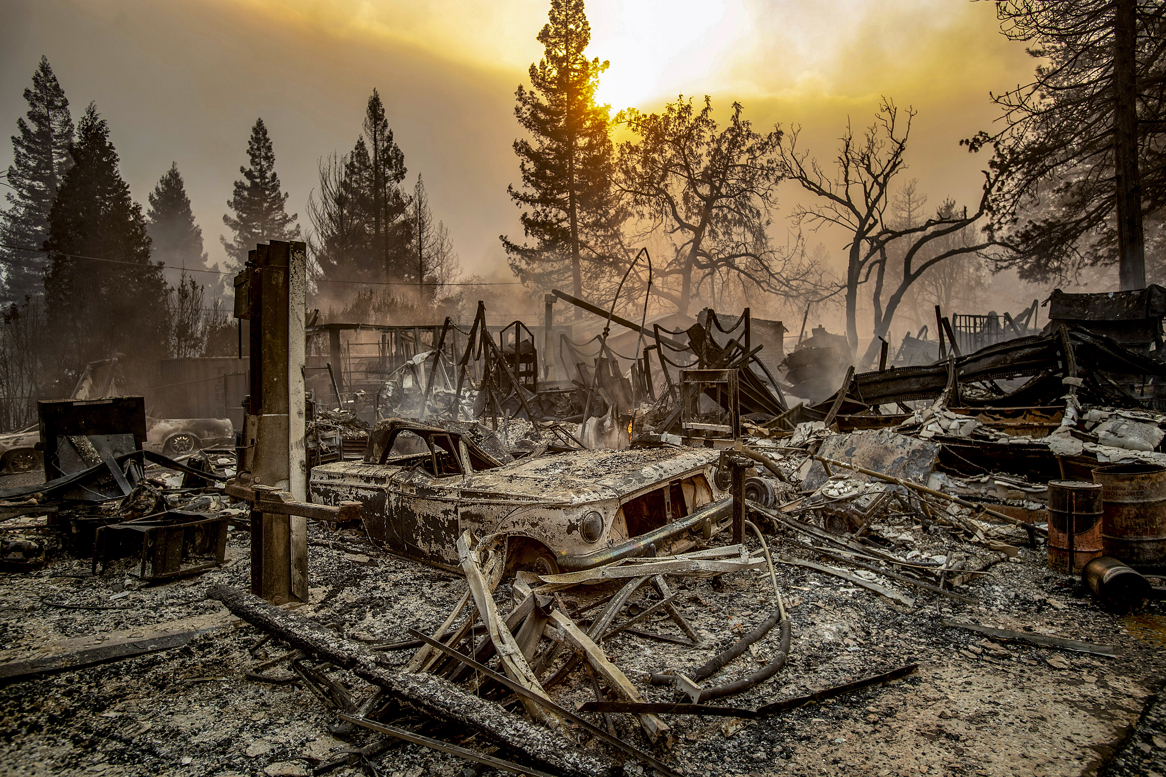 Slide 55 of 57: A vintage car rests among debris as the Camp Fire tears through Paradise, Calif., on Thursday, Nov. 8, 2018. Tens of thousands of people fled a fast-moving wildfire Thursday in Northern California, some clutching babies and pets as they abandoned vehicles and struck out on foot ahead of the flames that forced the evacuation of an entire town.